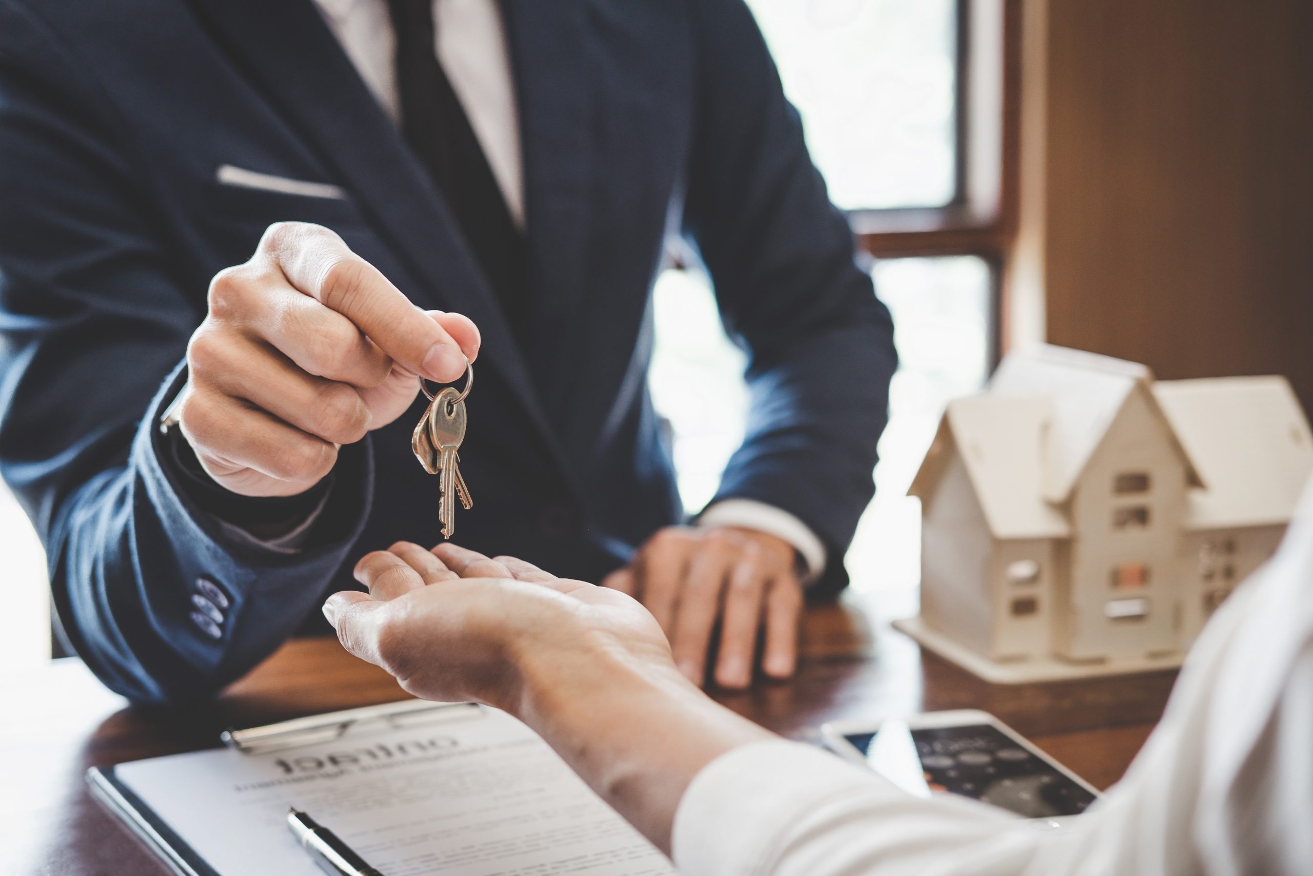 Real estate agent Sales manager holding filing keys to customer after signing rental lease contract of sale purchase agreement, concerning mortgage loan offer for and house insurance.